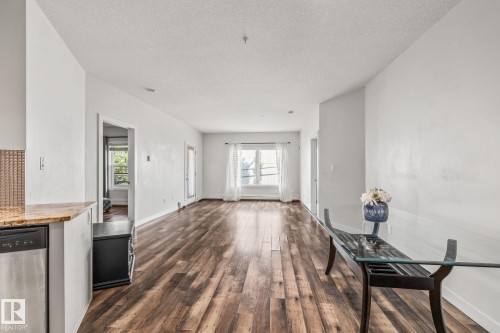 The property features an open-concept living space with hardwood flooring and white walls - 212 10611 117 Street, Edmonton, AB - Indoor Photo Showing Other Room