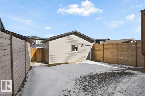 The property features a detached building with light-colored horizontal siding, a dark roof, and a small window - 204 Charlesworth Drive, Edmonton, AB - Outdoor With Exterior