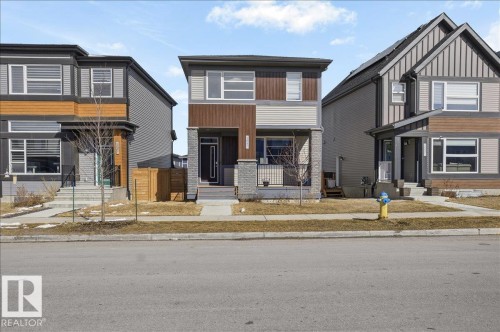 The property features a contemporary exterior design with a combination of neutral-toned siding and contrasting wood-look accents - 204 Charlesworth Drive, Edmonton, AB - Outdoor With Facade