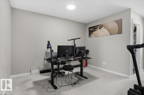 This room features light grey carpeting, white baseboards, and a circular ceiling light fixture - 204 Charlesworth Drive, Edmonton, AB - Indoor Photo Showing Office