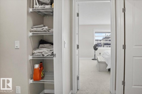 The property features a closet with wire shelving and a room with light-colored carpet and a window - 204 Charlesworth Drive, Edmonton, AB - Indoor