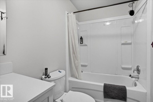 Bathroom featuring a white vanity with a countertop, a toilet, and a combination shower and bathtub with a shower curtain - 204 Charlesworth Drive, Edmonton, AB - Indoor Photo Showing Bathroom