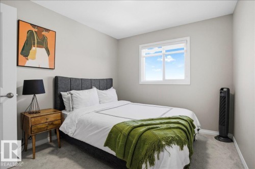 This room features light-colored walls and grey carpeting - 204 Charlesworth Drive, Edmonton, AB - Indoor Photo Showing Bedroom