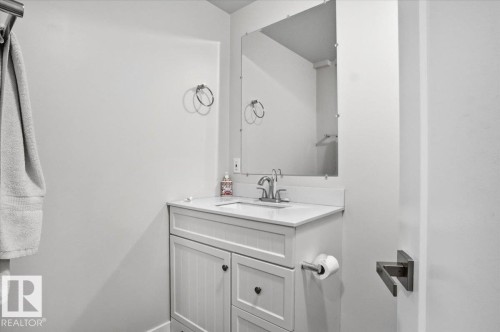Modern bathroom vanity with a white countertop and a mirrored wall - 204 Charlesworth Drive, Edmonton, AB - Indoor Photo Showing Bathroom