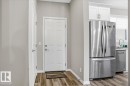 The property features durable flooring and a modern kitchen equipped with a stainless steel refrigerator and white cabinetry - 204 Charlesworth Drive, Edmonton, AB  - Indoor 