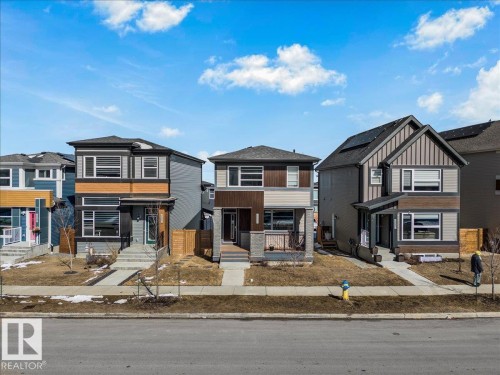 The property features a two-story design with a mix of horizontal and vertical siding, and a covered front entryway - 204 Charlesworth Drive, Edmonton, AB - Outdoor With Facade