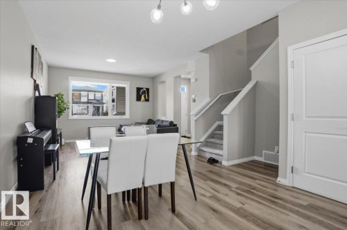 The main living area features durable flooring, a large window, and a staircase with white railings - 204 Charlesworth Drive, Edmonton, AB - Indoor