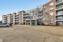 The property features a multi-story building with a light-colored facade and a darker brown section, offering numerous balconies with white railings - 319 17404 64 Avenue, Edmonton, AB  - Outdoor With Balcony With Facade 