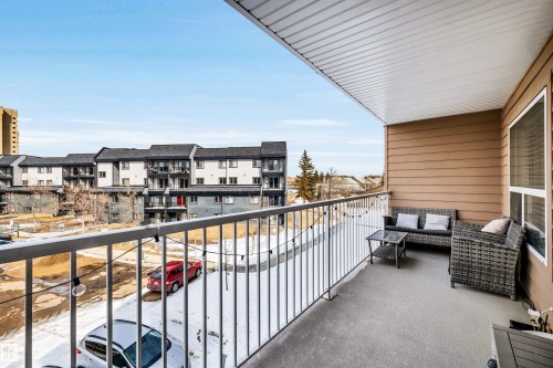 The property features a spacious balcony with a white railing, providing views of the surrounding buildings and outdoor areas - 319 17404 64 Avenue, Edmonton, AB - Outdoor With Balcony With Exterior