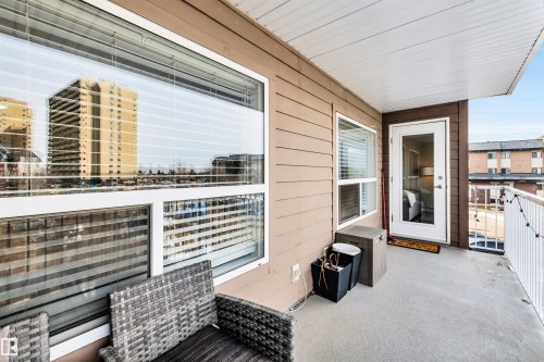 This property features a private balcony with a concrete floor, a white railing, and a view of the surrounding buildings - 319 17404 64 Avenue, Edmonton, AB - Outdoor