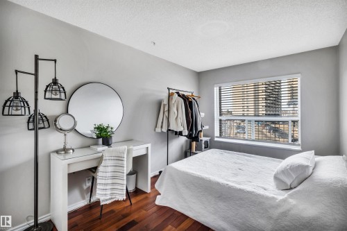 This room features hardwood floors and a window with blinds, offering exterior views - 319 17404 64 Avenue, Edmonton, AB - Indoor Photo Showing Bedroom
