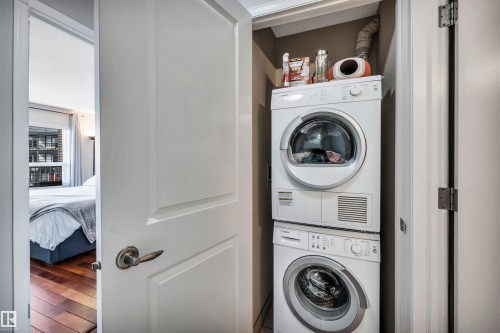 The property features an in-unit stacked washer and dryer, conveniently located within a dedicated closet - 319 17404 64 Avenue, Edmonton, AB - Indoor Photo Showing Laundry Room