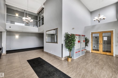 The property features a spacious lobby with high ceilings and a tiled floor - 319 17404 64 Avenue, Edmonton, AB - Indoor Photo Showing Other Room
