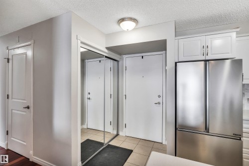 Entryway featuring a white door, mirrored closet doors, and recessed lighting - 319 17404 64 Avenue, Edmonton, AB - Indoor