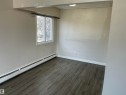 This room features dark-toned flooring, a window providing natural light, and baseboard heating - 12335 132 Avenue, Edmonton, AB  - Indoor Photo Showing Other Room 