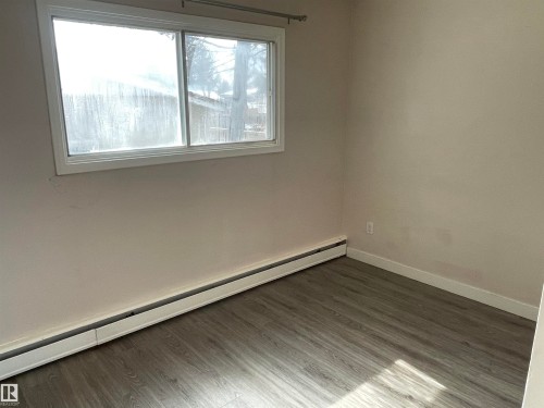 Room featuring a window, baseboard heating, and wood-look flooring - 12335 132 Avenue, Edmonton, AB - Indoor Photo Showing Other Room