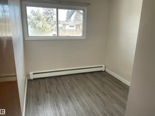 This room features wood-look flooring and a window providing natural light - 12335 132 Avenue, Edmonton, AB - Indoor Photo Showing Other Room