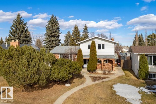 The property features a two-story design with white siding and a brick lower level, complemented by a gabled roof - 1412 Knottwood Road E, Edmonton, AB - Outdoor