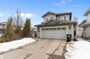 The property features a two-story home with light grey siding, a two-car garage with a concrete driveway, and a gabled roof - 16748 118 Street, Edmonton, AB  - Outdoor 