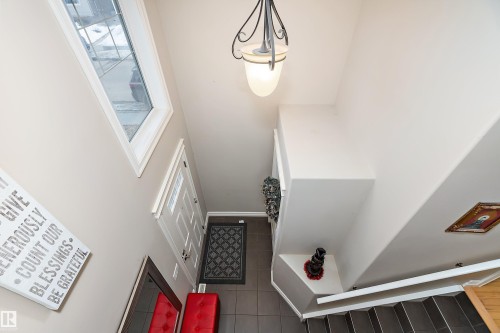Inviting entryway with a white paneled door, tiled flooring, and a decorative light fixture - 16748 118 Street, Edmonton, AB - Indoor Photo Showing Other Room