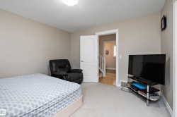 This room features neutral wall paint, carpet flooring, a white interior door, and white trim - 