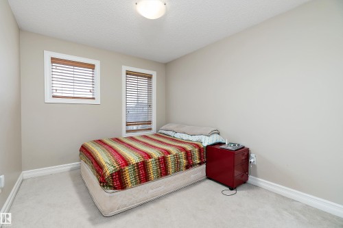 Bedroom featuring two windows with horizontal blinds, light-colored walls, and carpeted flooring - 16748 118 Street, Edmonton, AB - Indoor Photo Showing Bedroom