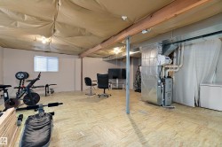 The property features an unfinished basement with exposed wooden ceiling beams and light-colored flooring - 