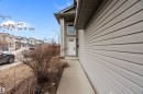 The property features a concrete walkway leading to the front entrance, which includes a white door with a window and an overhead light fixture - 16748 118 Street, Edmonton, AB  - Outdoor 
