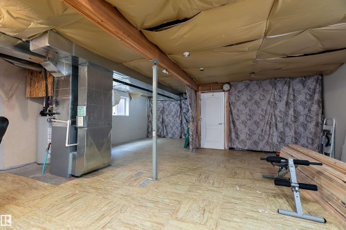 This property features an unfinished basement with a partial ceiling, exposed wooden beams, and a water heater - 16748 118 Street, Edmonton, AB - Indoor