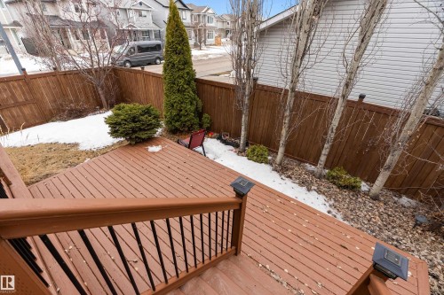 The property features an outdoor deck with a brown wooden railing and dark balusters - 16748 118 Street, Edmonton, AB - Outdoor