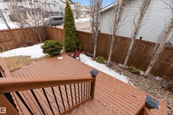 The property features an outdoor deck with a brown wooden railing and dark balusters - 
