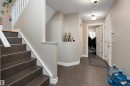 The property features a staircase with dark tile steps and white railings, a hallway with tiled flooring, and light-colored walls throughout - 16748 118 Street, Edmonton, AB  - Indoor Photo Showing Other Room 