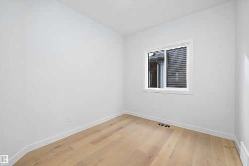 This room features light hardwood flooring, white walls, and a window with white trim - 34 Cannes Cove, St. Albert, AB - Indoor Photo Showing Other Room