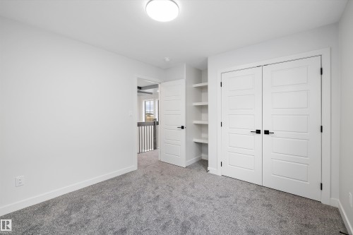 This room features light grey carpeting, white walls, and a contemporary ceiling light fixture - 34 Cannes Cove, St. Albert, AB - Indoor