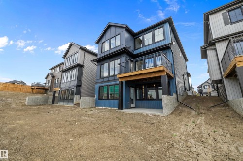 The property features a multi-story exterior with blue and dark grey siding, multiple windows, and a balcony with black railings - 34 Cannes Cove, St. Albert, AB - Outdoor