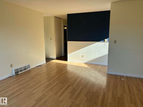 Open concept space featuring wood-finish flooring - 4129 134A Avenue Nw, Edmonton, AB - Indoor Photo Showing Other Room