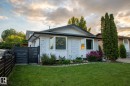 The property features a well-maintained lawn, established landscaping with flowering bushes, and mature trees - 2626 49 Street, Edmonton, AB  - Outdoor 