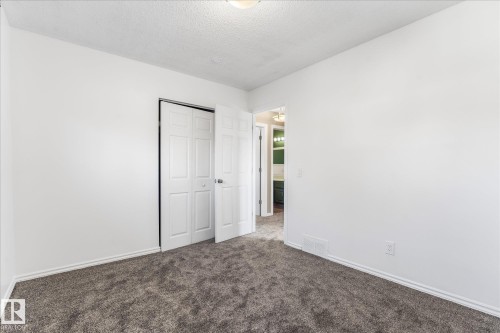 This room features white walls, dark grey carpeting, and white baseboards - 2626 49 Street, Edmonton, AB - Indoor Photo Showing Other Room