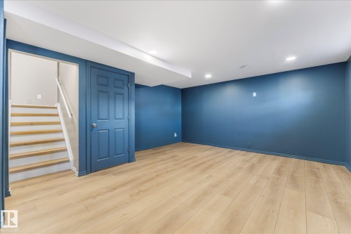 Open concept room featuring light wood flooring, blue walls, and recessed lighting - 2626 49 Street, Edmonton, AB - Indoor Photo Showing Other Room