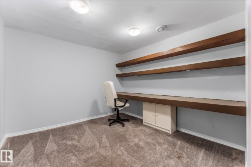 This room features grey walls, a built-in desk with a lower cabinet, and two upper shelves - 2626 49 Street, Edmonton, AB - Indoor