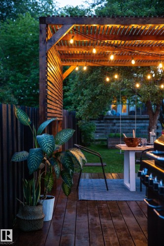 This outdoor space features a wooden pergola adorned with string lights, providing an inviting ambiance - 2626 49 Street, Edmonton, AB - Outdoor With Deck Patio Veranda