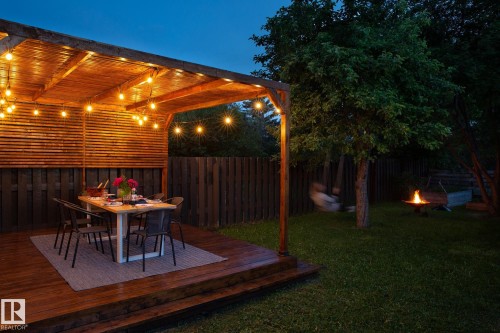 The property features a wooden deck with an overhead pergola, illuminated by string lights - 2626 49 Street, Edmonton, AB - Outdoor With Deck Patio Veranda