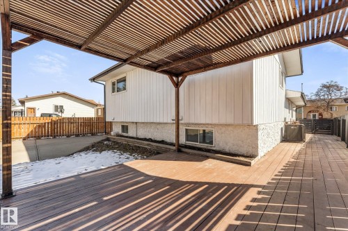 The property features a spacious outdoor deck with a slatted wooden pergola, offering an inviting area for outdoor enjoyment - 2626 49 Street, Edmonton, AB - Outdoor With Deck Patio Veranda With Exterior