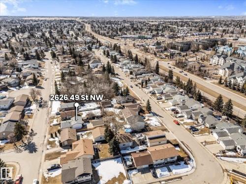 Aerial view of the property and surrounding neighborhood, featuring residential streets, houses with various roof styles, and mature trees - 2626 49 Street, Edmonton, AB - Outdoor With View