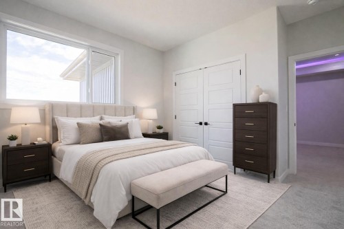 This bedroom features a large window providing natural light, white walls, and light-colored carpeting - Rural Leduc County, AB - Indoor Photo Showing Bedroom