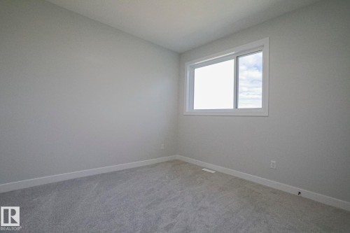 This room features light grey walls, white trim, and grey carpet - Rural Leduc County, AB - Indoor Photo Showing Other Room
