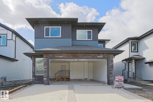 This property features a modern exterior with a multi-level design, incorporating both horizontal siding and stone accents - Rural Leduc County, AB - Outdoor