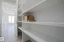 The property features extensive white built-in shelving, providing generous storage - Rural Leduc County, AB  - Indoor Photo Showing Other Room 
