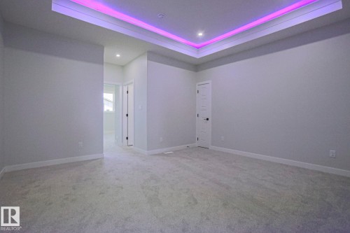 A spacious room featuring wall-to-wall carpeting, recessed lighting, and tray ceiling with accent lighting - Rural Leduc County, AB - Indoor Photo Showing Other Room