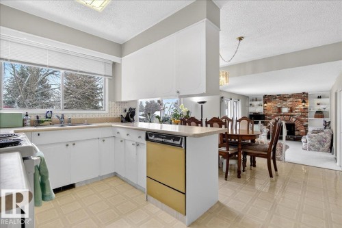 The kitchen features white cabinetry, a sink with a window view, and patterned flooring - 391 Lee Ridge Road, Edmonton, AB - Indoor Photo Showing Kitchen
